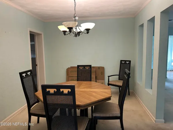 a view of a dining room with furniture and chandelier