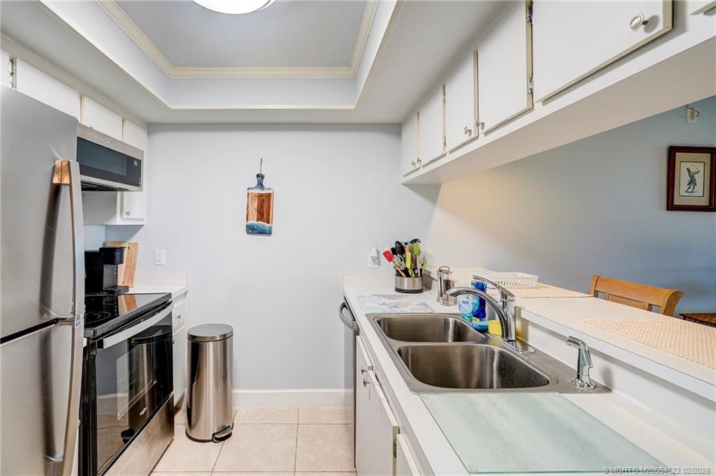 40 Northeast Plantation Road, Unit 309 Jensen Beach, FL 34957 - Photo 13 of 44 a kitchen with a sink and a stove top oven