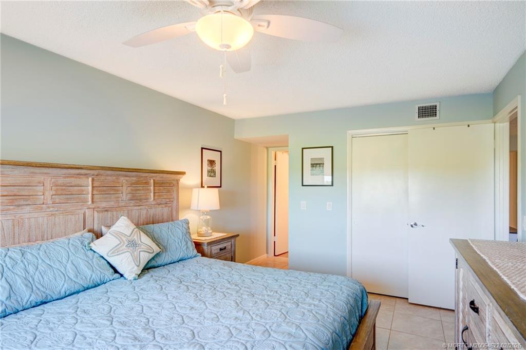 40 Northeast Plantation Road, Unit 309 Jensen Beach, FL 34957 - Photo 30 of 44 a bedroom with a large bed and a chandelier