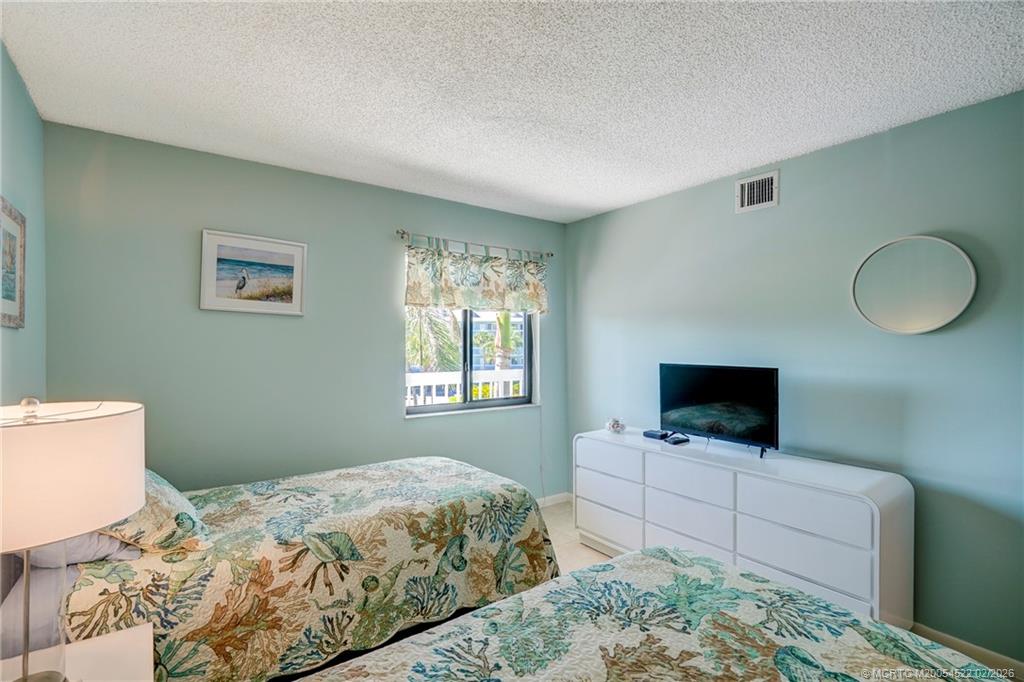 40 Northeast Plantation Road, Unit 309 Jensen Beach, FL 34957 - Photo 37 of 44 a bedroom with a bed and a television