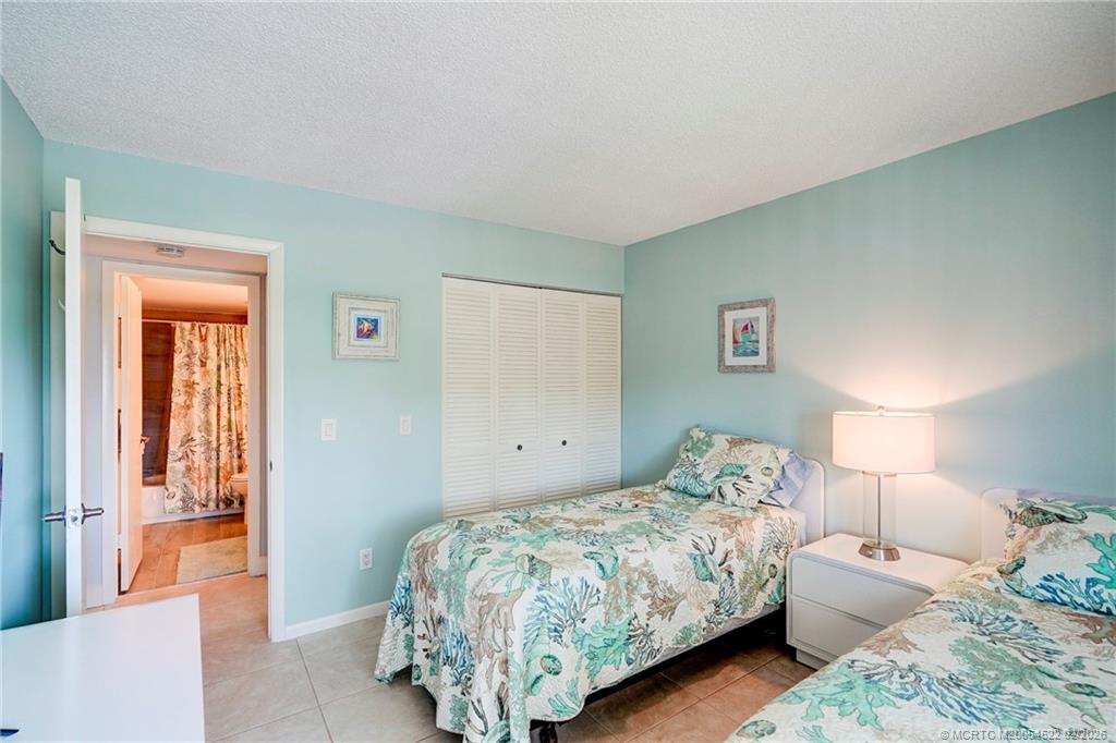 40 Northeast Plantation Road, Unit 309 Jensen Beach, FL 34957 - Photo 39 of 44 a bedroom with a bed and a couch