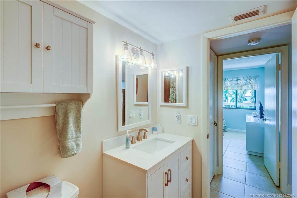 40 Northeast Plantation Road, Unit 309 Jensen Beach, FL 34957 - Photo 41 of 44 a bathroom with a sink and mirror