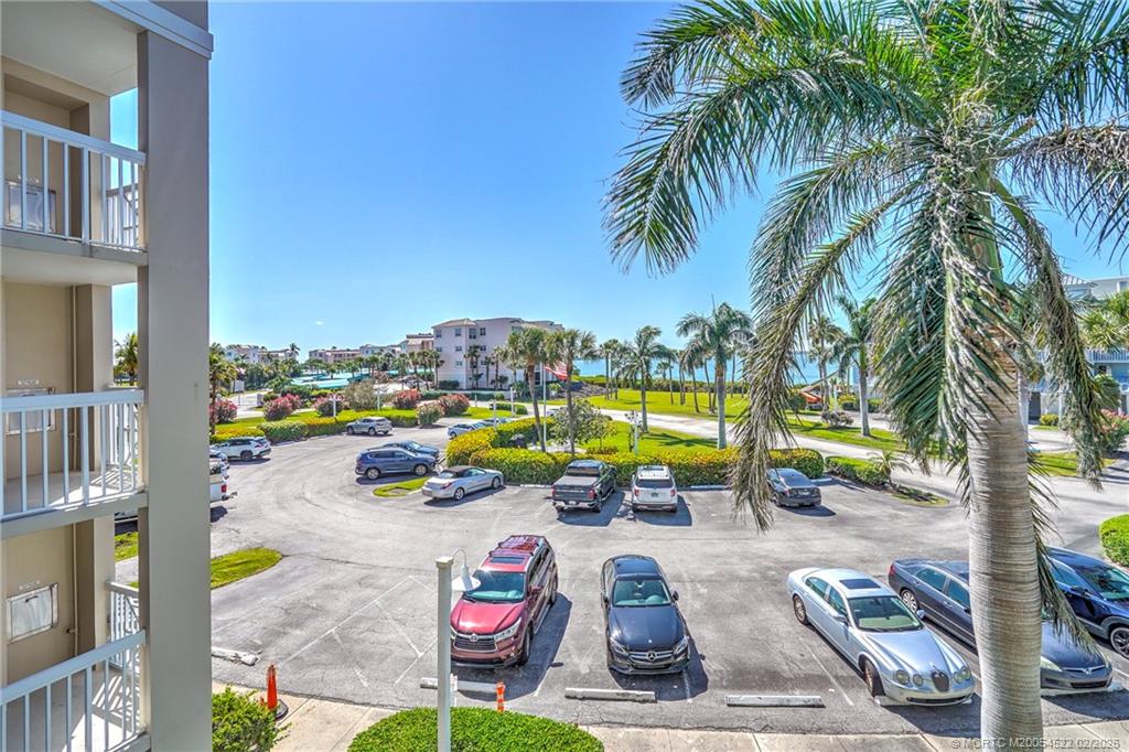 40 Northeast Plantation Road, Unit 309 Jensen Beach, FL 34957 - Photo 9 of 44 a view of a swimming pool with a lounge chair and palm trees