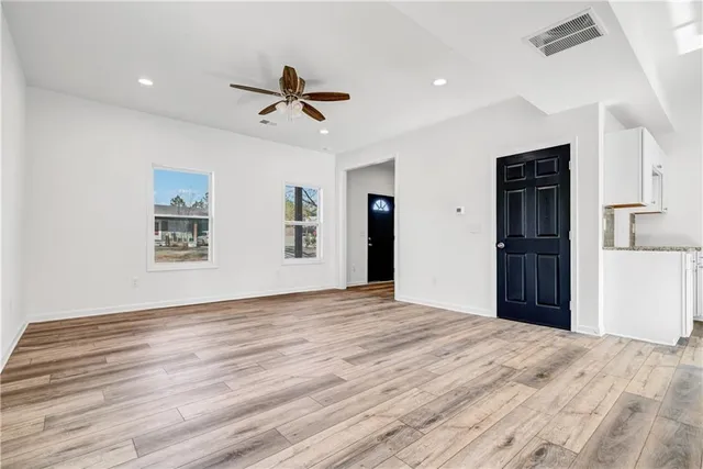 a view of a livingroom with wooden floor and a ceiling fan