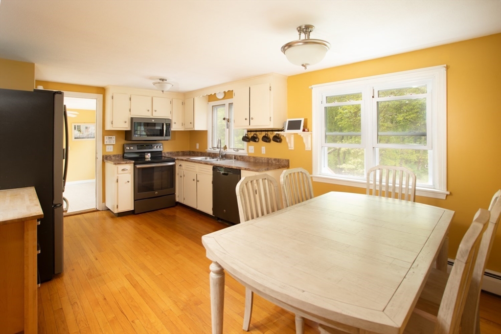 1332 Main Road Westport, MA 02790 - Photo 13 of 39 a kitchen with stainless steel appliances granite countertop a stove a refrigerator a sink a dining table and chairs