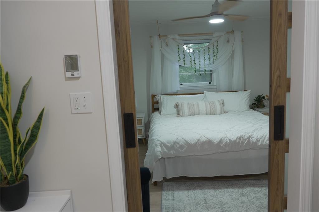 330 Ivy Trail Hartwell, GA 30643 - Photo 12 of 34 a bedroom with a bed table and a potted plant