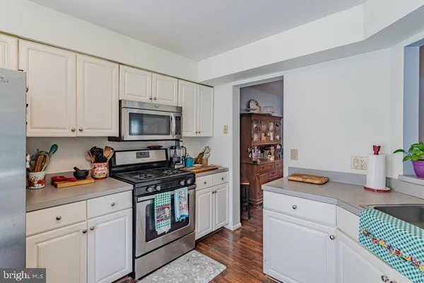 a kitchen with white cabinets and appliances