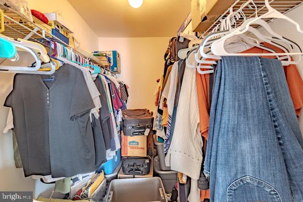 a view of walk in closet with clothes and shoes