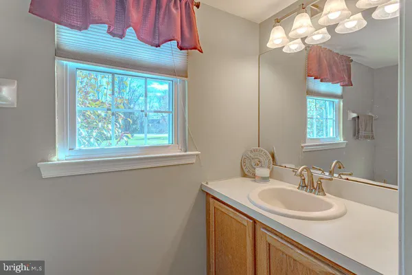 a bathroom with a sink vanity and a mirror