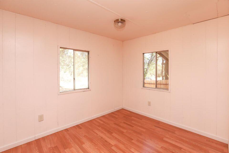 16947 Spring Creek Road Redding, CA 96003 - Photo 7 of 22 an empty room with wooden floor and windows