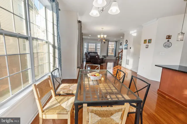 a view of a dining room with furniture a chandelier and wooden floor