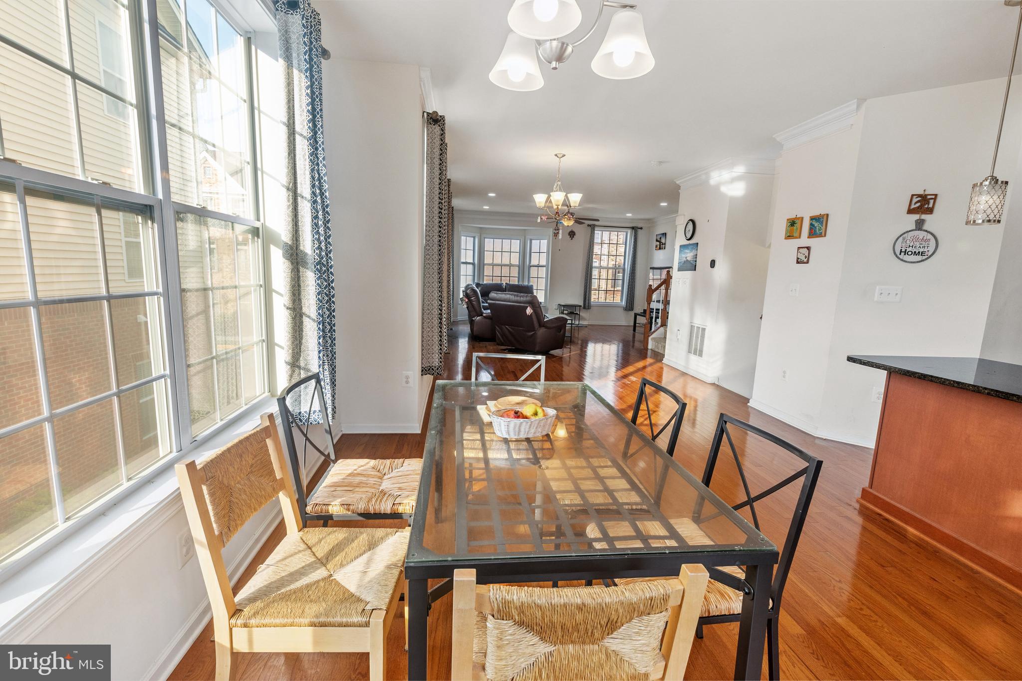 22551 Cambridgeport Square Ashburn, VA 20148 - Photo 15 of 49 a view of a dining room with furniture a chandelier and wooden floor