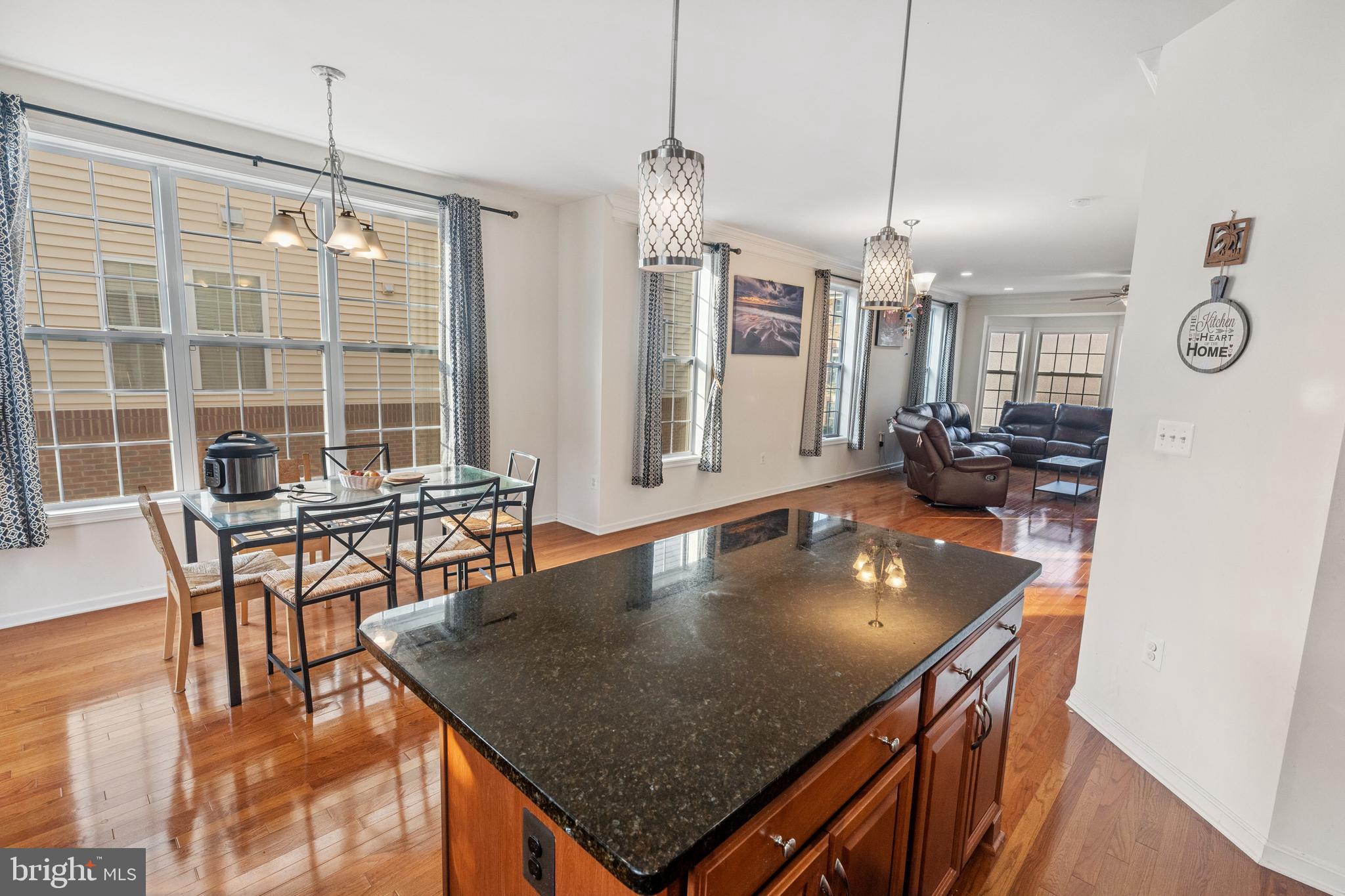 22551 Cambridgeport Square Ashburn, VA 20148 - Photo 19 of 49 a kitchen with a table chairs and wooden floor