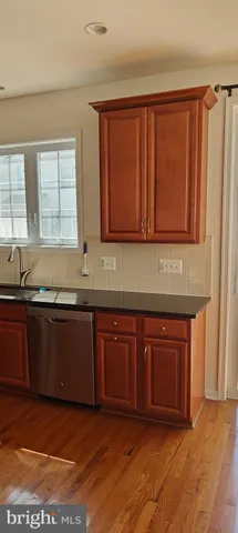 a kitchen with granite countertop a sink cabinets and a wooden floor