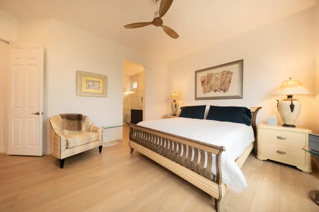 a spacious bedroom with a bed and a painting on the wall