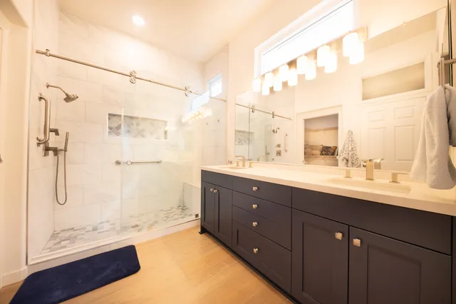 a bathroom with a tub sink shower and mirror