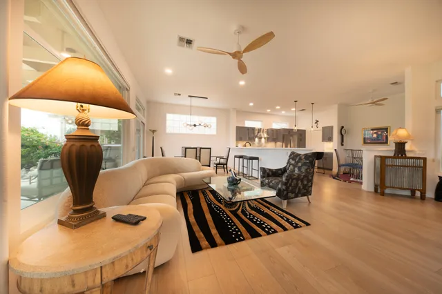 a living room with furniture a flat screen tv and kitchen view