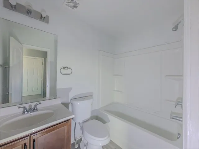 a bathroom with a sink toilet vanity and shower