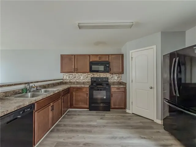 a kitchen with stainless steel appliances granite countertop a stove sink and refrigerator