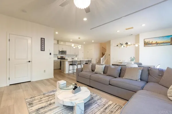 a living room with furniture and a dining table with wooden floor