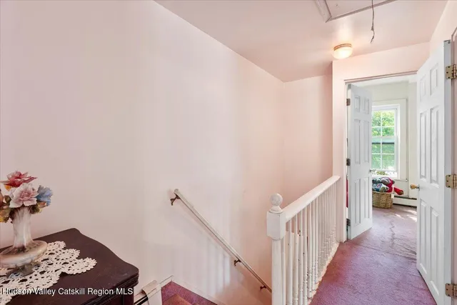 a view of a hallway to room with wooden floor