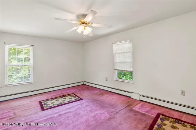 an empty room with windows and ceiling fan