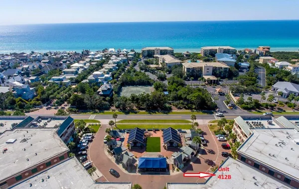 an aerial view of a city with lots of residential buildings ocean and mountain view in back