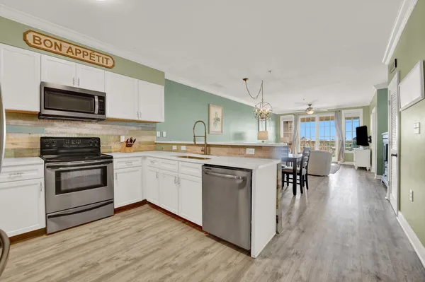 a kitchen with a sink cabinets and wooden floor