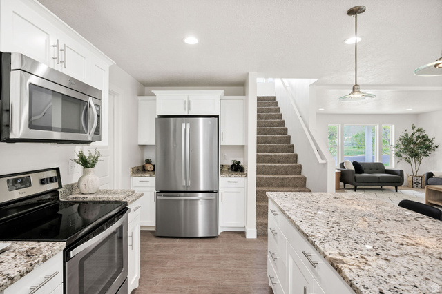 1552 Sumac Drive Logan, UT 84321 - Photo 11 of 72 Kitchen featuring white cabinetry, stainless steel appliances, and wood-finish flooring