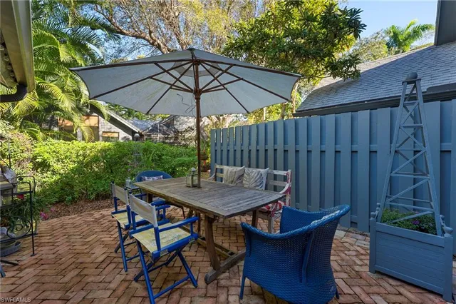 a view of wooden table and chairs under an umbrella
