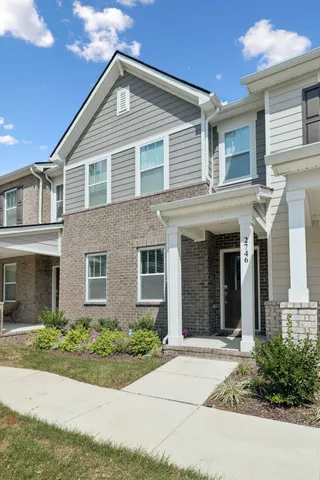 a view of a white house with potted plants