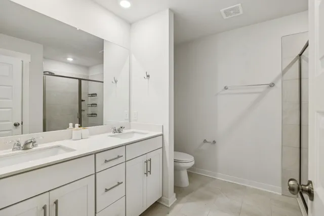 a bathroom with a granite countertop sink a toilet and a mirror