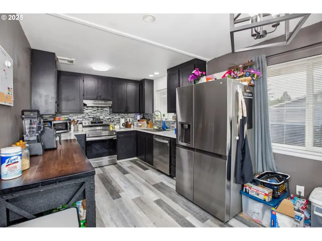 a kitchen with stainless steel appliances granite countertop a refrigerator sink and cabinets