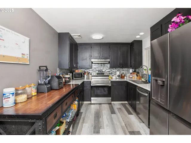 a kitchen with granite countertop a refrigerator stove top oven and sink