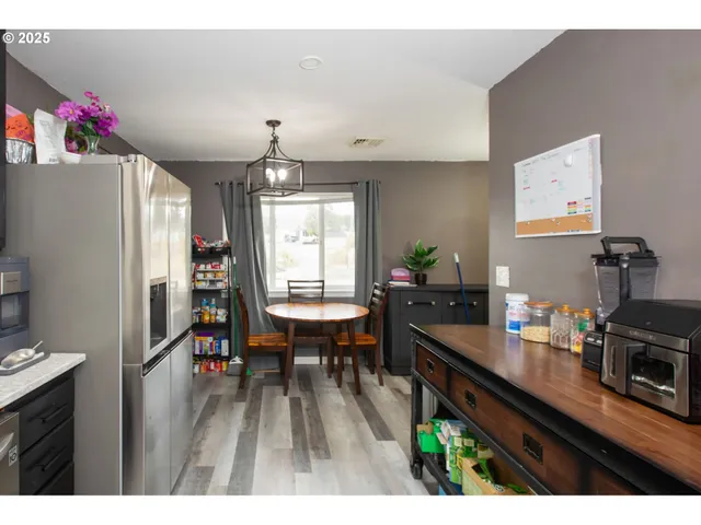 a kitchen with sink refrigerator dining table and chairs