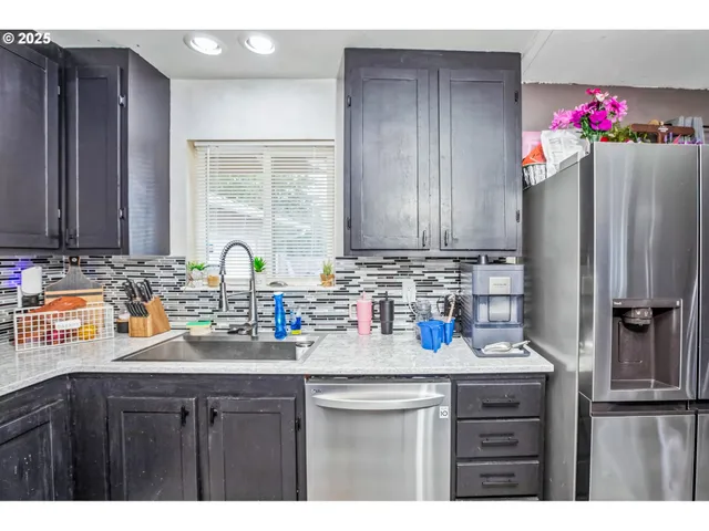 a kitchen with sink a refrigerator and cabinets