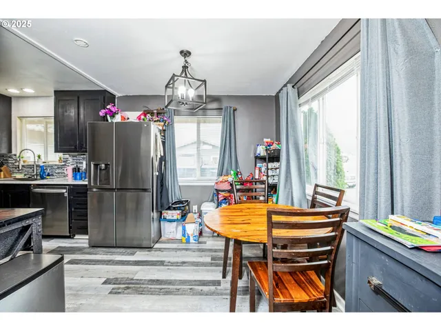 a kitchen with a refrigerator and a dining table