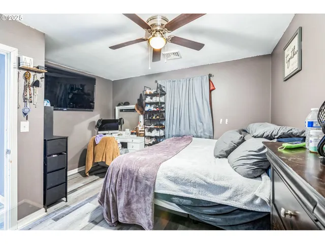 a bedroom with a bed a flat screen tv and a couch