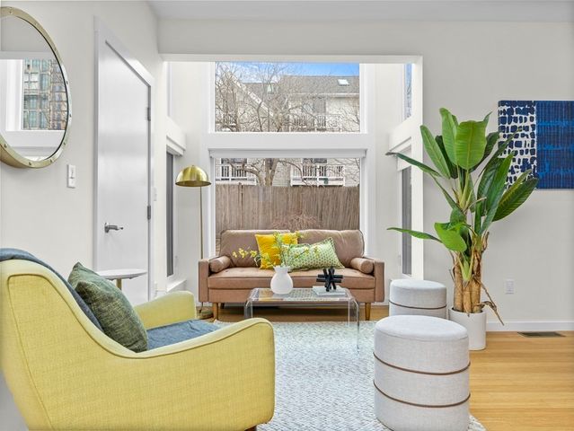 a living room with furniture a chandelier and a potted plant