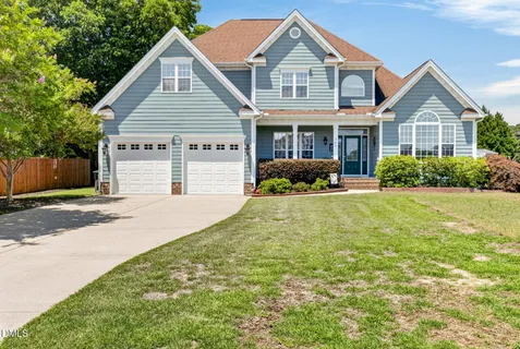a front view of a house with a yard and garage