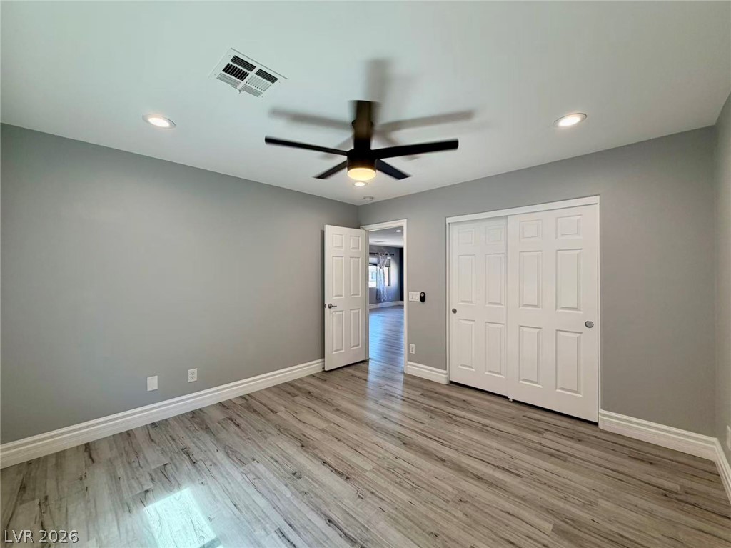 135 Tall Ruff Drive Las Vegas, NV 89148 - Photo 22 of 29 A well-lit bedroom features wood-look flooring and a functional ceiling fan for optimal comfort.