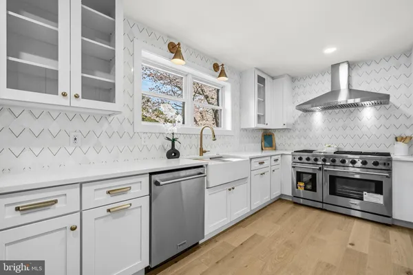 a kitchen with stainless steel appliances white cabinets and a sink