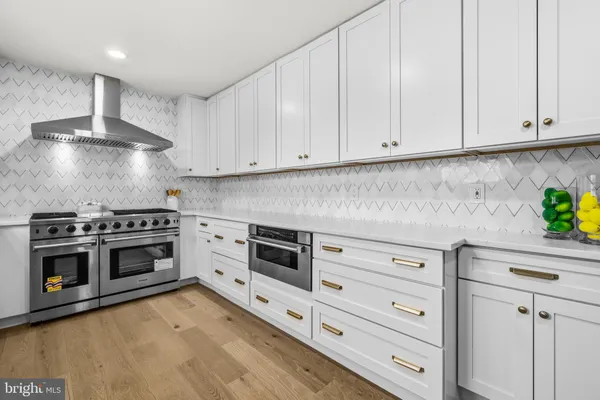 a kitchen with white cabinets and stainless steel appliances