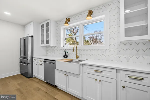 a kitchen with white cabinets and stainless steel appliances