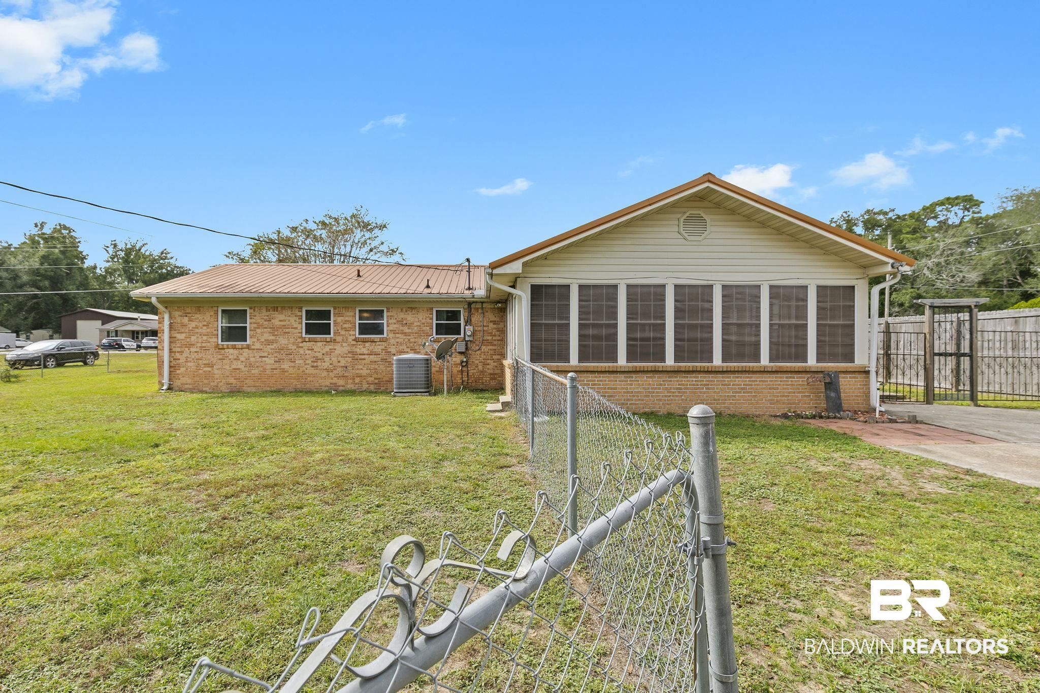 13108 6th Street Lillian, AL 36549 - Photo 33 of 39 Rear view of property featuring a yard and a sunroom