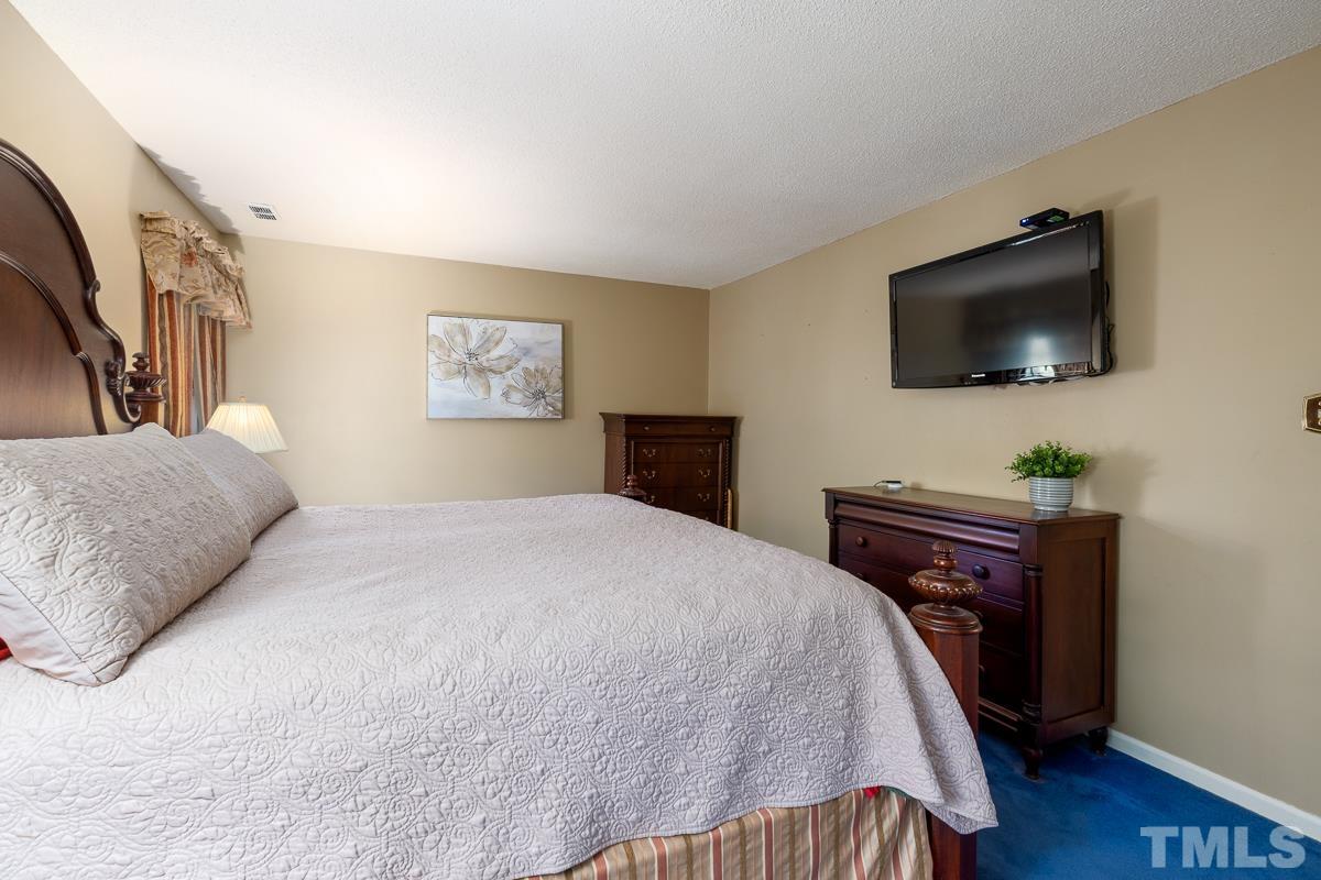 7320 Old Hundred Road Raleigh, NC 27613 - Photo 18 of 39 a bedroom with a bed and a flat screen tv