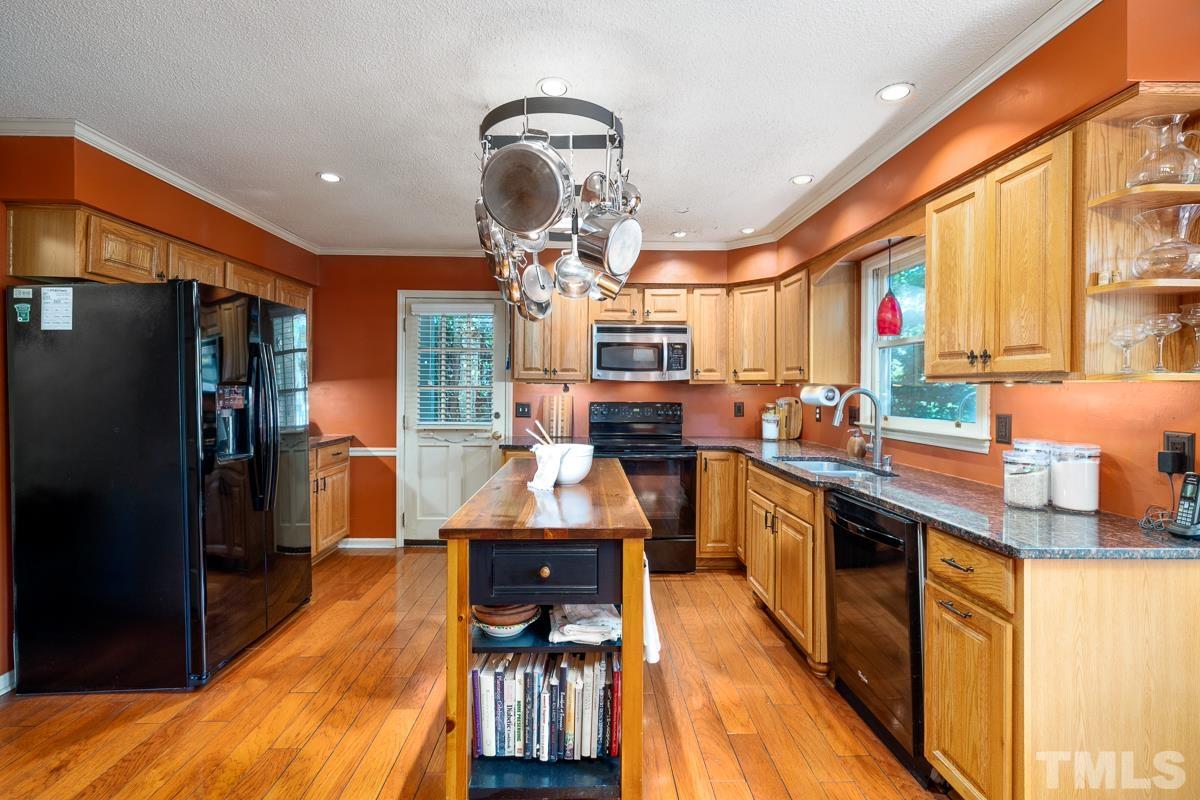 7320 Old Hundred Road Raleigh, NC 27613 - Photo 10 of 39 a kitchen with stainless steel appliances granite countertop a refrigerator a stove and a wooden floors