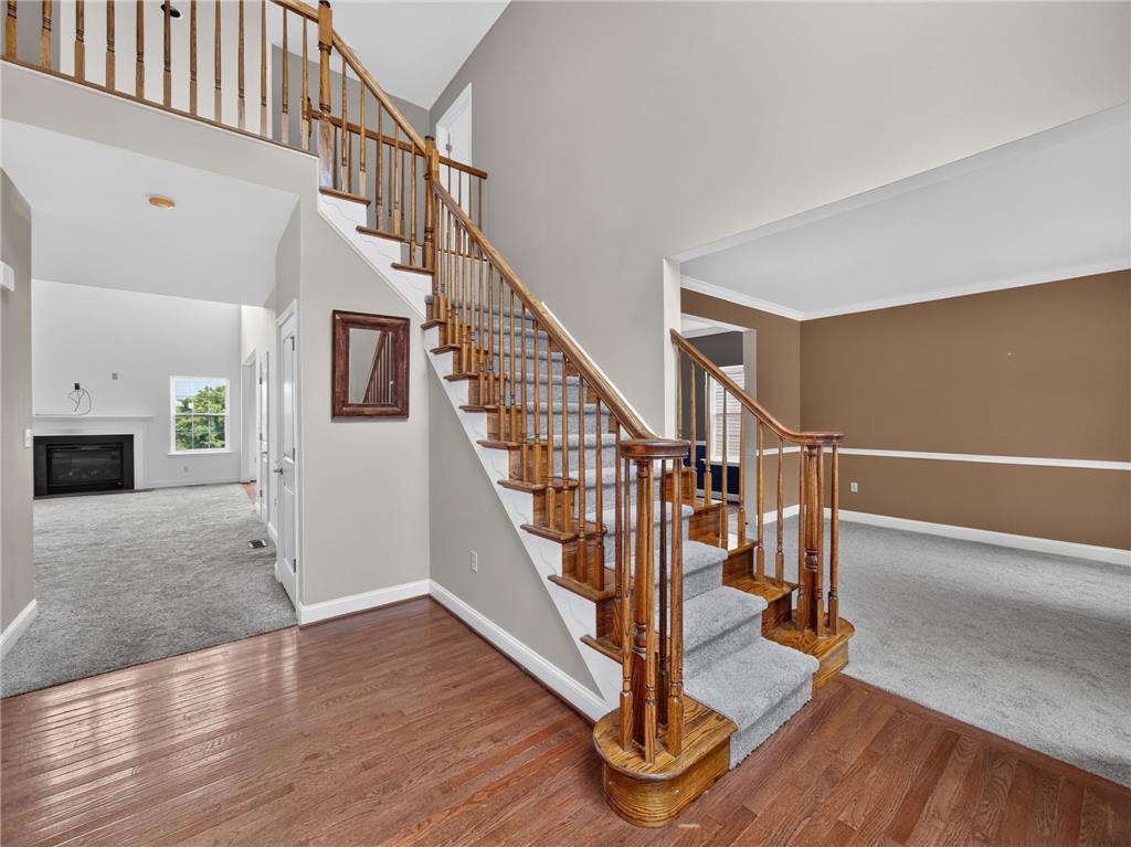 3821 Rittenhouse Road Lower Macungie Township, PA 18062 - Photo 18 of 62 Elegant hardwood flooring in the foyer transitions to a carpeted staircase with a classic wooden banister.