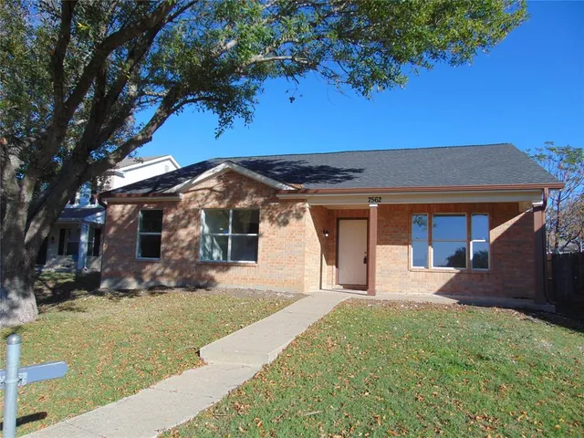 a front view of a house with a yard outdoor seating and garage