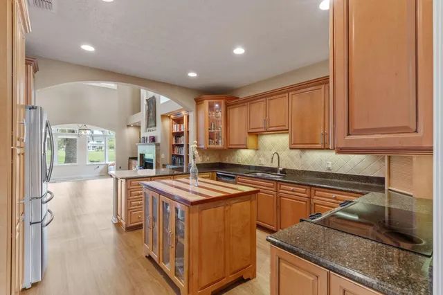 a kitchen that has a sink a stove and chairs in it